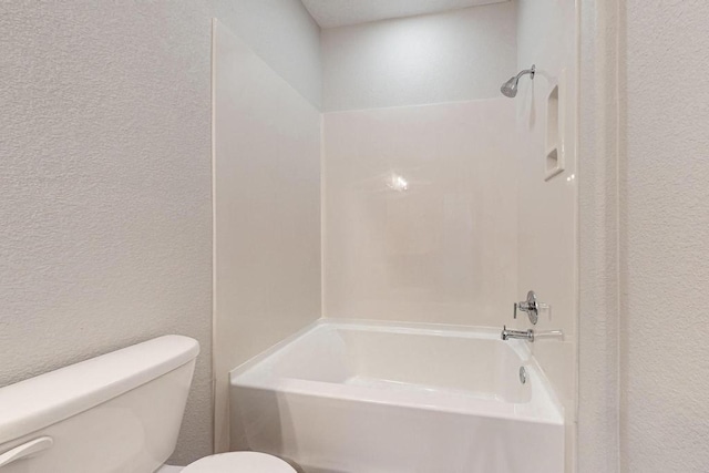 bathroom featuring washtub / shower combination and toilet