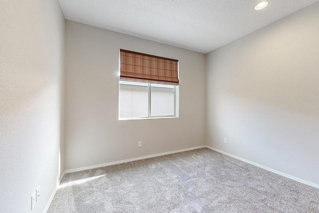 carpeted spare room featuring a textured ceiling