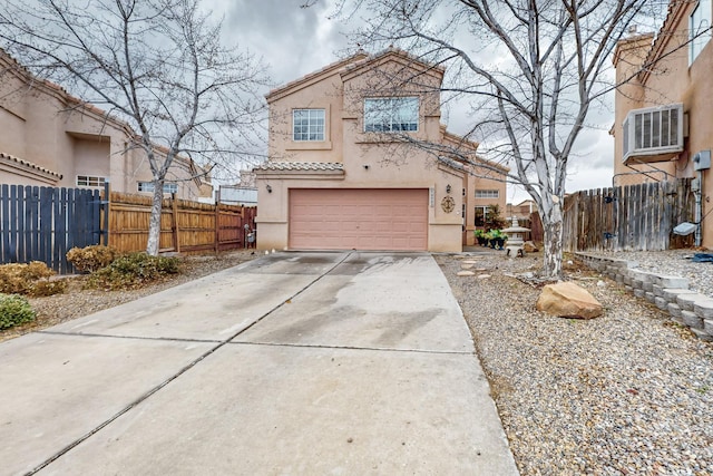 view of front of home with a garage and a wall mounted air conditioner