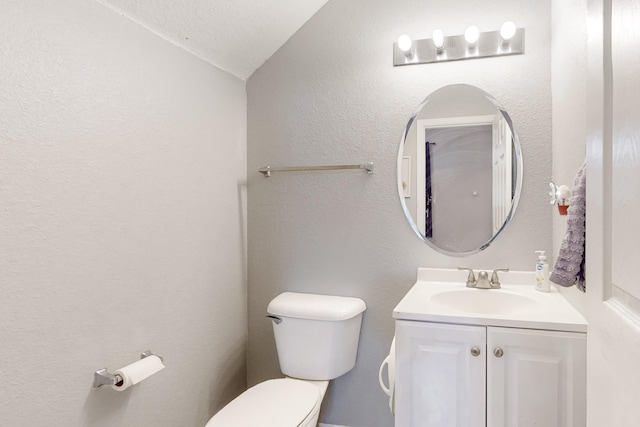 bathroom with vanity, vaulted ceiling, and toilet