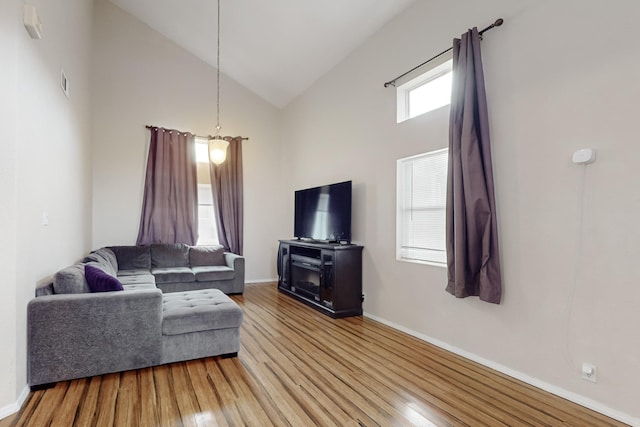 living room featuring wood-type flooring and high vaulted ceiling