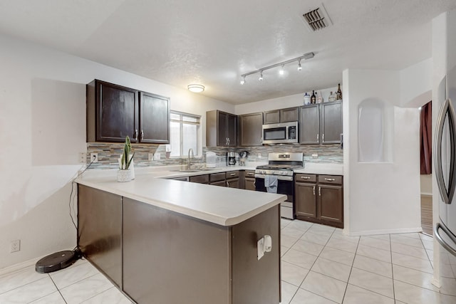 kitchen with dark brown cabinetry, kitchen peninsula, and appliances with stainless steel finishes