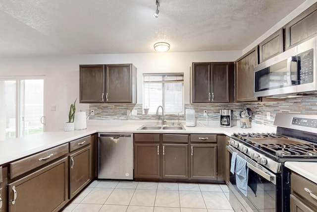 kitchen featuring appliances with stainless steel finishes, tasteful backsplash, sink, dark brown cabinetry, and a textured ceiling