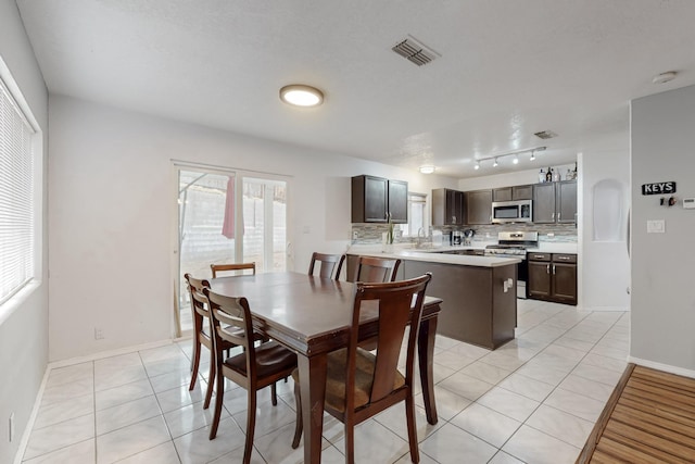 dining space with light tile patterned flooring and sink