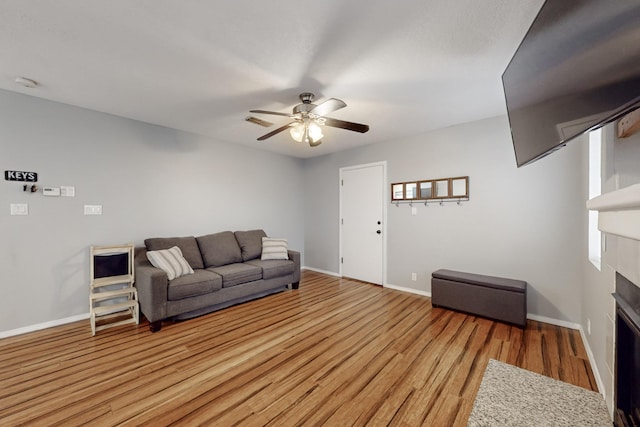 living room with light hardwood / wood-style flooring and ceiling fan