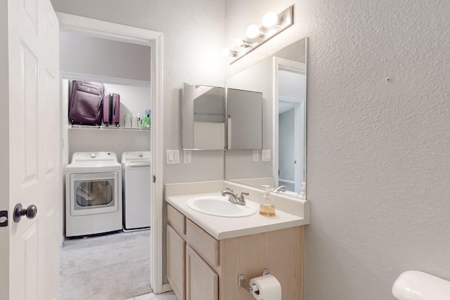 bathroom with vanity, independent washer and dryer, and toilet