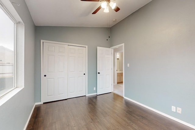 unfurnished bedroom featuring vaulted ceiling, dark hardwood / wood-style floors, ceiling fan, and a closet