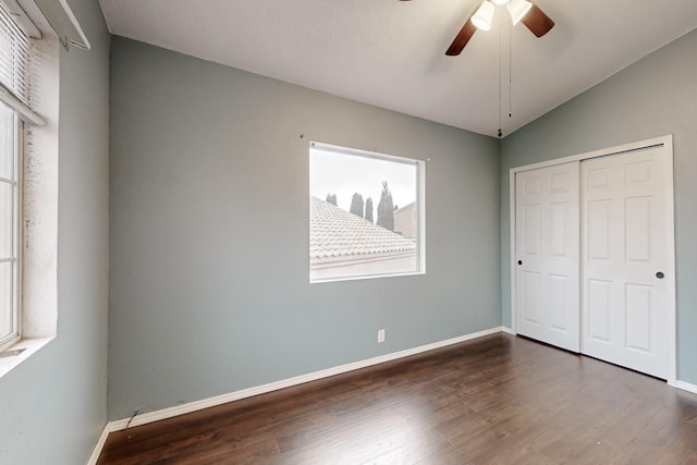 unfurnished bedroom featuring ceiling fan, lofted ceiling, dark hardwood / wood-style flooring, and a closet