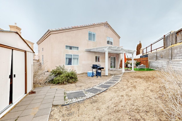 back of house with a storage unit and a pergola