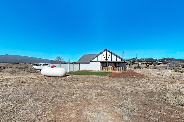 view of yard featuring a rural view, a mountain view, and a porch