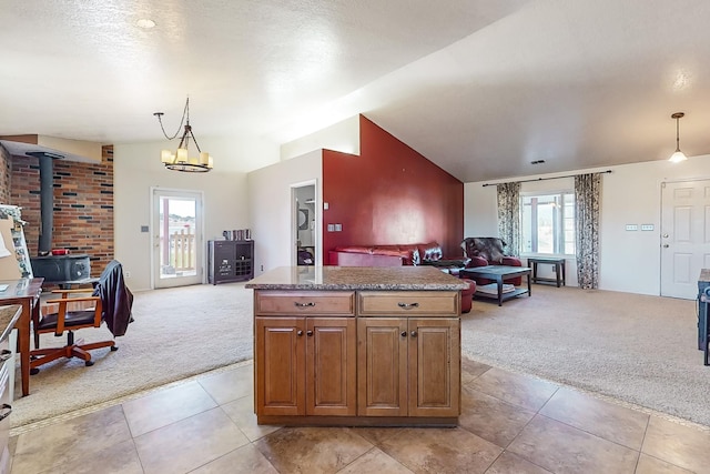 kitchen featuring light carpet, pendant lighting, lofted ceiling, and a healthy amount of sunlight