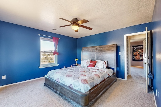 bedroom featuring ceiling fan, light colored carpet, and a textured ceiling