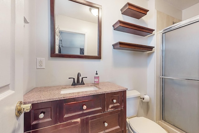 bathroom with walk in shower, vanity, and toilet