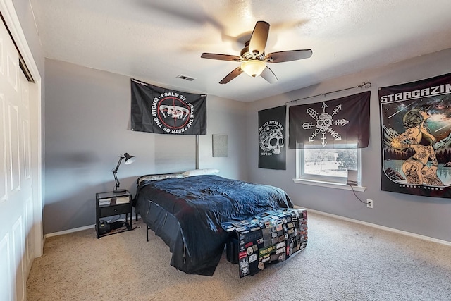 bedroom featuring carpet floors, a textured ceiling, ceiling fan, and a closet