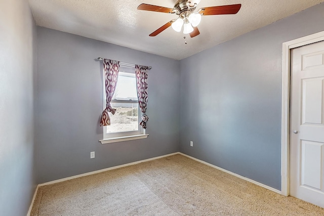 carpeted empty room featuring ceiling fan and a textured ceiling