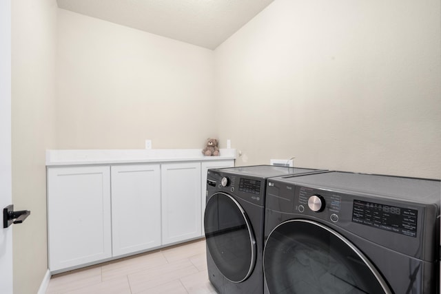 laundry area with cabinets and washing machine and clothes dryer