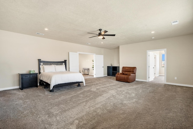 bedroom featuring ceiling fan, carpet flooring, and a textured ceiling