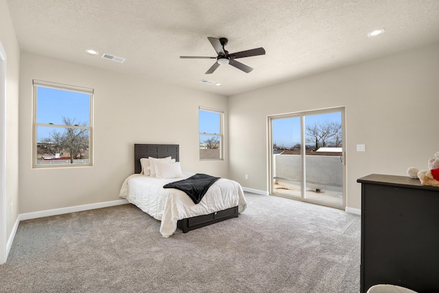 carpeted bedroom with ceiling fan, a textured ceiling, and access to outside