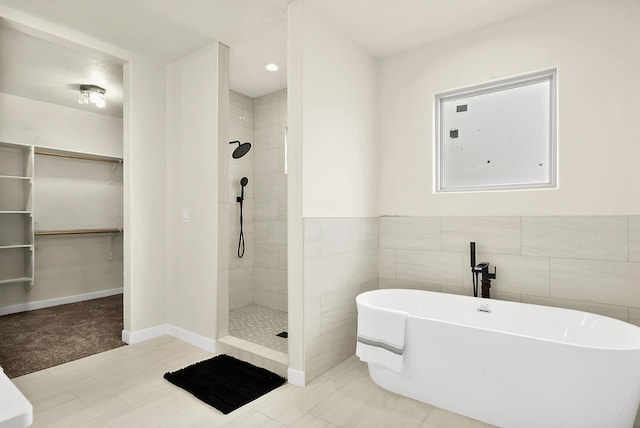 bathroom featuring tile walls and plus walk in shower