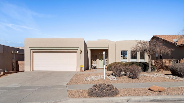 pueblo-style house with central AC unit and a garage