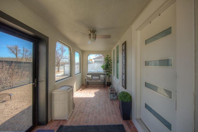 sunroom / solarium featuring ceiling fan