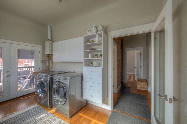 clothes washing area with french doors, tankless water heater, cabinets, separate washer and dryer, and light hardwood / wood-style floors