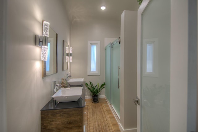 bathroom featuring vanity, hardwood / wood-style flooring, and a shower with shower door