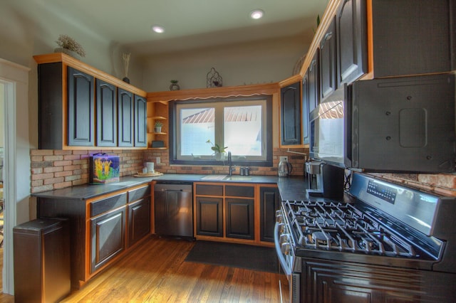 kitchen featuring tasteful backsplash, sink, light wood-type flooring, and appliances with stainless steel finishes