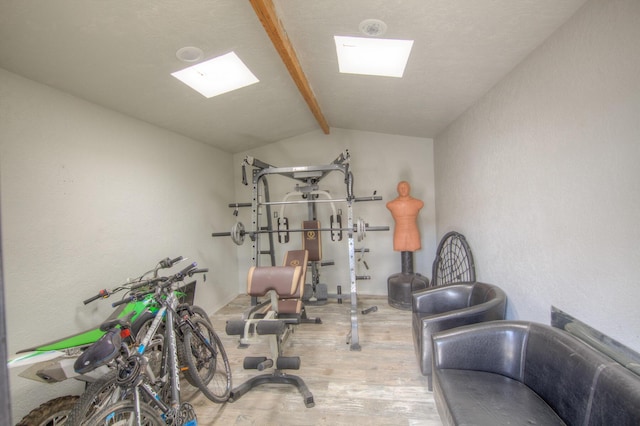 exercise area featuring vaulted ceiling and hardwood / wood-style floors