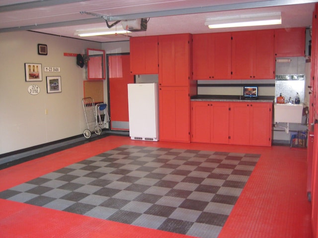 garage with sink, a garage door opener, and refrigerator