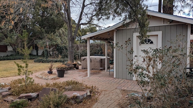 view of outbuilding with a lawn and a hot tub