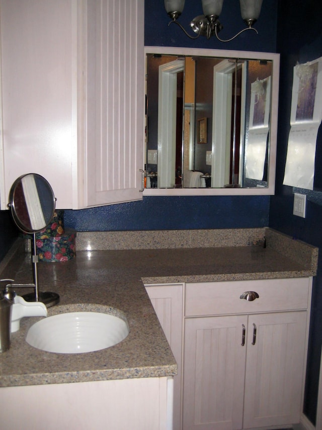 bathroom with an inviting chandelier and vanity