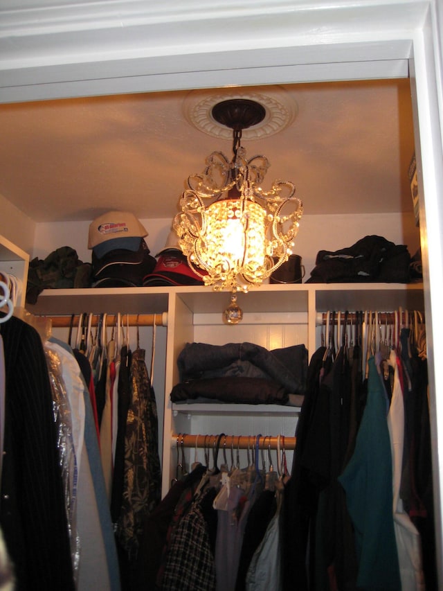 walk in closet with an inviting chandelier