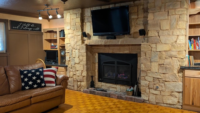 living room featuring crown molding, parquet flooring, a stone fireplace, and a textured ceiling