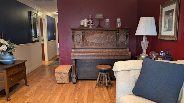 living area featuring ornamental molding and light hardwood / wood-style floors