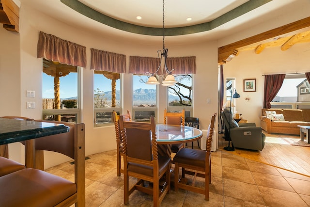 6816 Nagoya Rd NE, Rio Rancho, NM 87144 - tiled dining space featuring a mountain view, a notable chandelier, plenty of natural light, and a raised ceiling