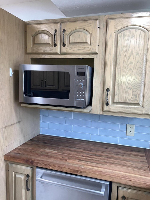 room details featuring backsplash, light brown cabinets, wooden counters, and appliances with stainless steel finishes