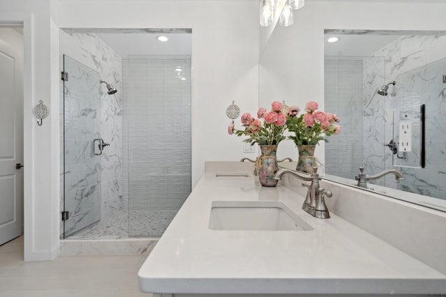 bathroom with a shower with door and vanity