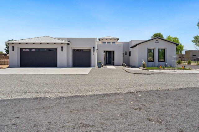 70 Camino De Claudio, Corrales, NM 87048 - view of front of home featuring driveway, fence, a garage, and stucco siding