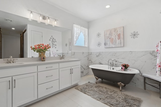 bathroom featuring vanity, a bathtub, and tile walls