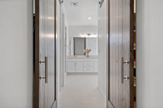 corridor featuring a barn door and sink