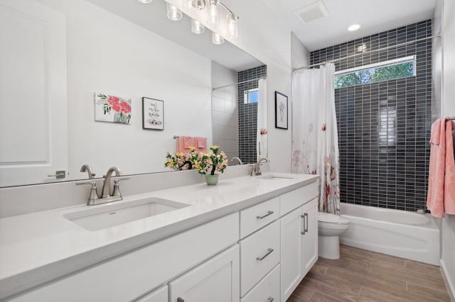 full bathroom with vanity, shower / tub combo, and toilet