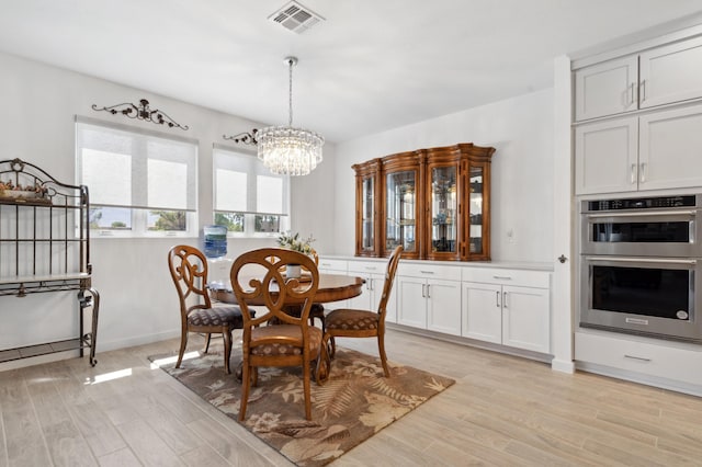 dining space with a chandelier and light hardwood / wood-style flooring