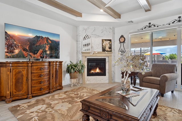 living room featuring light hardwood / wood-style flooring, a high end fireplace, and beamed ceiling