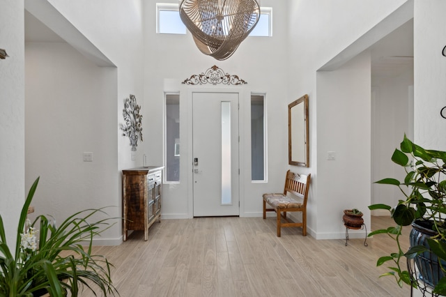 entryway with a towering ceiling and light hardwood / wood-style flooring