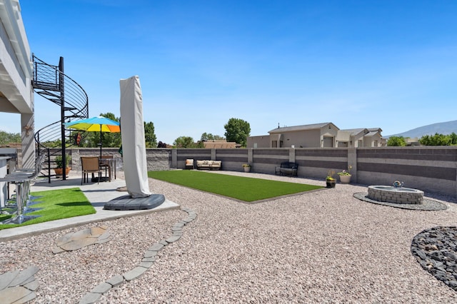 view of yard featuring a mountain view, a patio area, and an outdoor fire pit