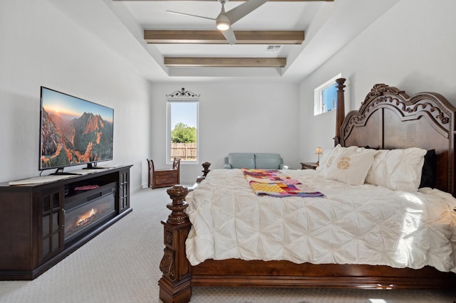 carpeted bedroom with ceiling fan and beam ceiling