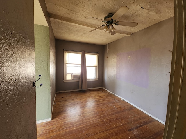 spare room with cooling unit, hardwood / wood-style floors, a textured ceiling, and ceiling fan