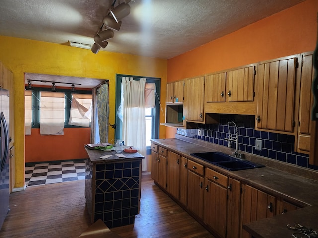 kitchen with dark wood-type flooring, sink, decorative backsplash, and a wealth of natural light