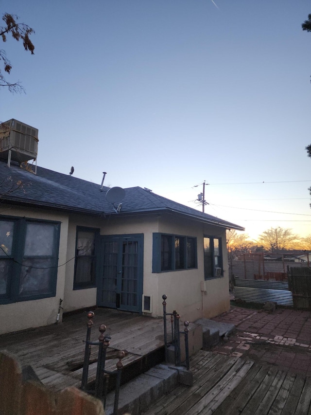 back house at dusk featuring a deck